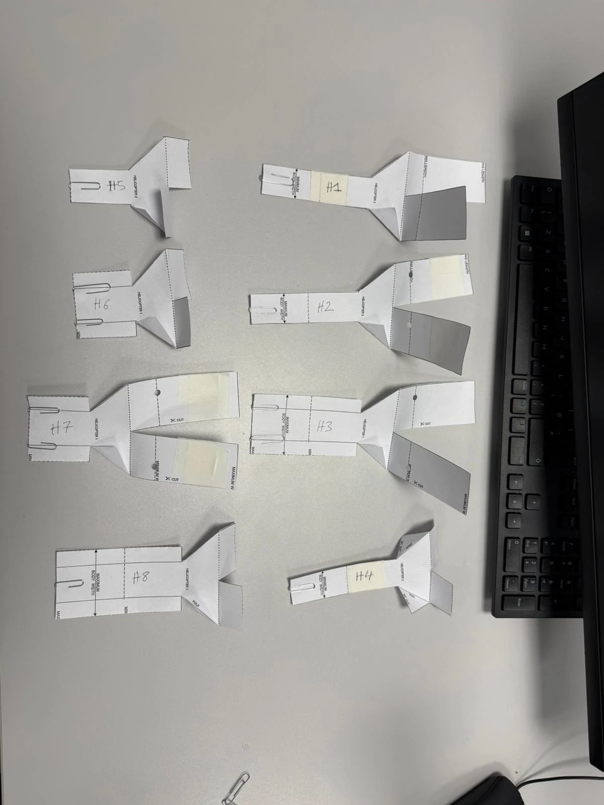 The eight paper helicopter configurations prepared for the experiment.