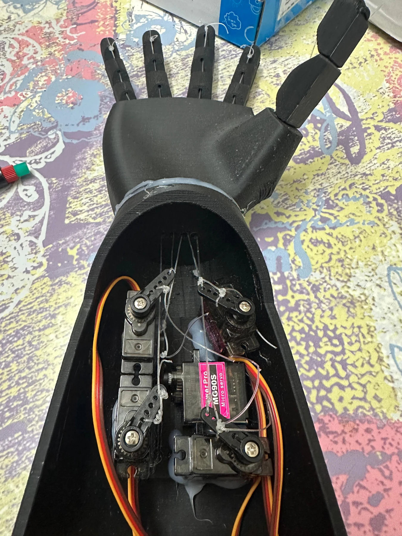The forearm opened to show actuation and electronic integration.